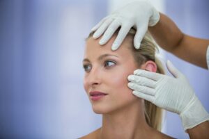 doctor examining female patients face from cosmetic treatment 107420 74088 تقنية شد الوجه الفرنسية